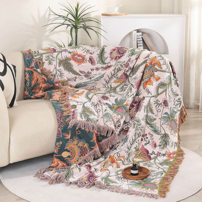 Boho floral cotton throw blanket draped over a sofa showing deep teal reverse side