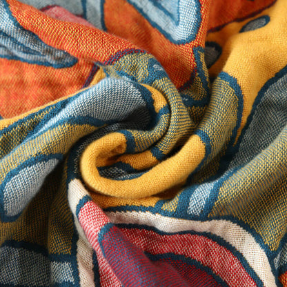 Close-up of boho geometric cotton throw blanket with muted blue and orange woven pattern