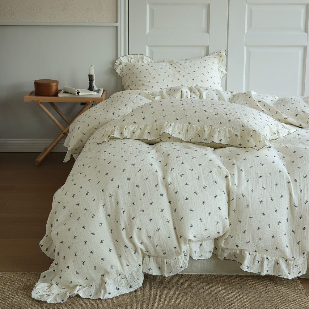 Full shot of a Cottagecore bed featuring the bow print ruffled cotton muslin duvet cover set. Shows the soft, lightweight bedding draped over the bed.
