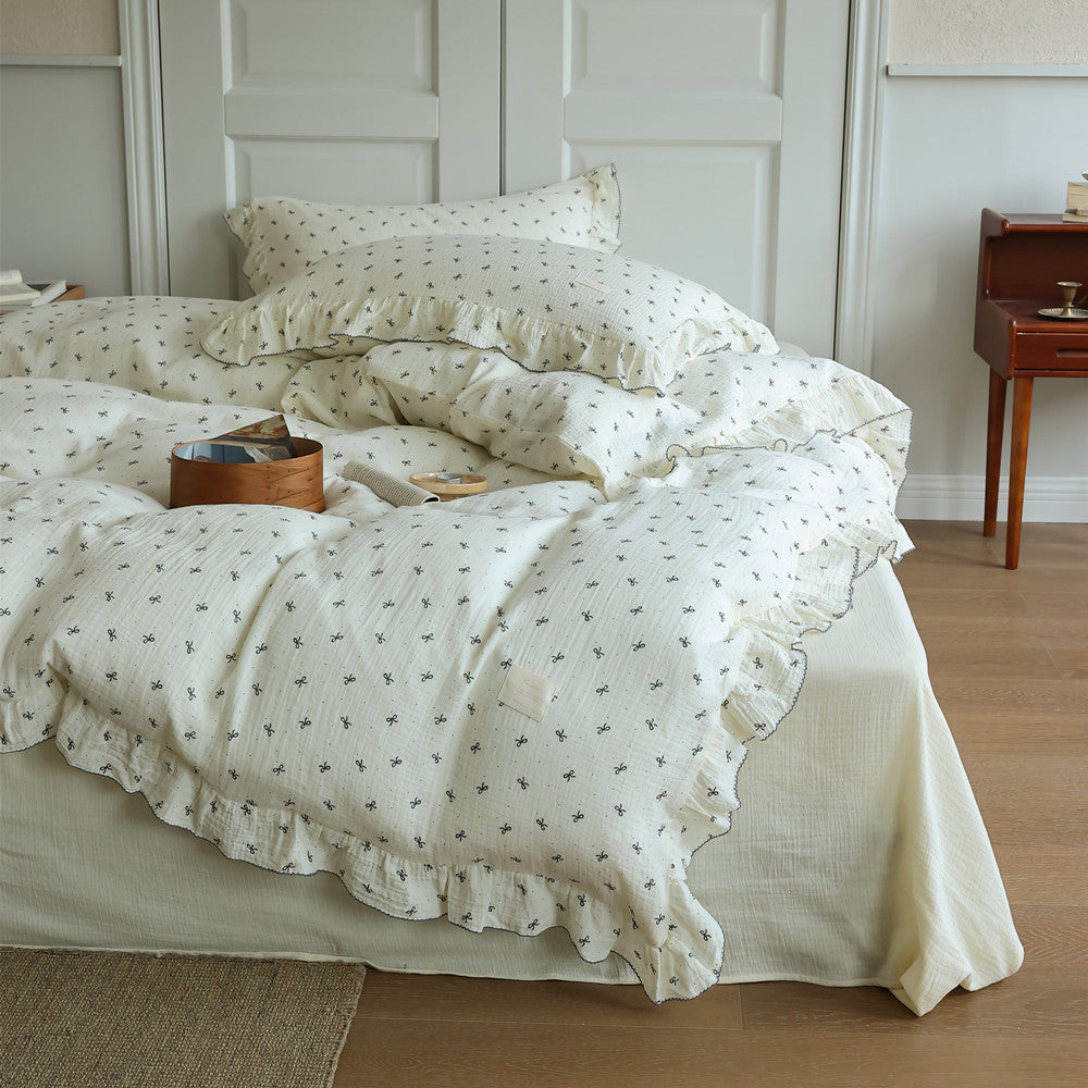 Close-up of the ruffled edge and bow print pattern on the muslin cotton gauze duvet cover. Highlights the breathable texture of the bedding set.