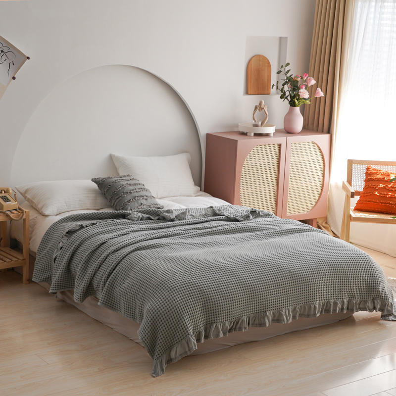 Modern bedroom styled with a soft grey breathable cotton waffle blanket on a white bed.
