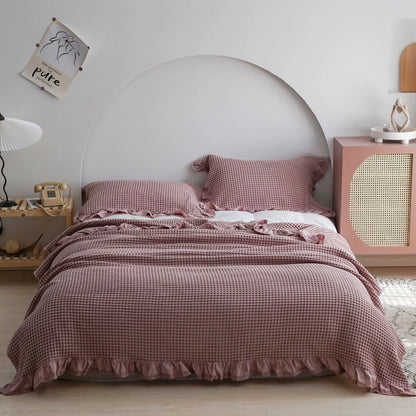 Dusty rose pink cotton waffle blanket and matching pillowcases with ruffle details.