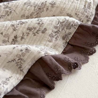 Macro detail of brown botanical floral cotton fabric with deep mocha embroidered ruffle trim