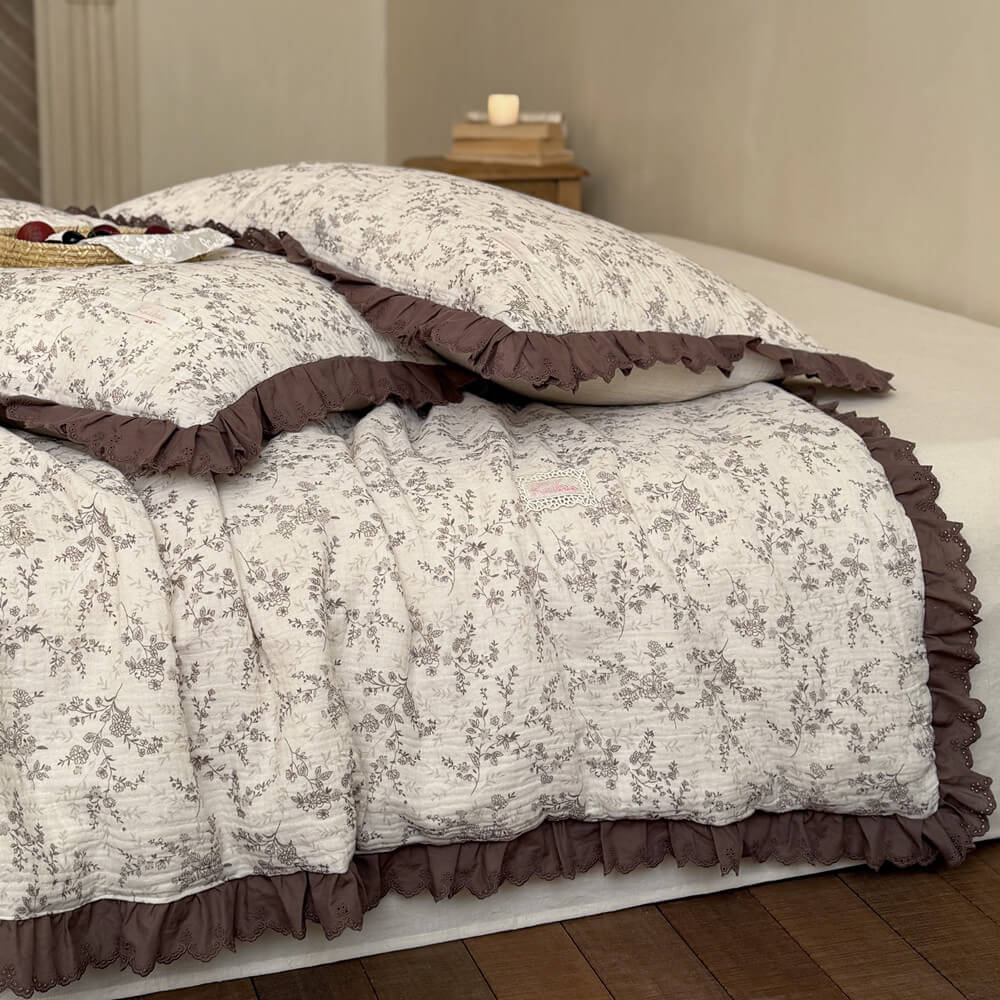 Close view of brown floral cotton comforter showing crinkled texture and deep ruffled trim