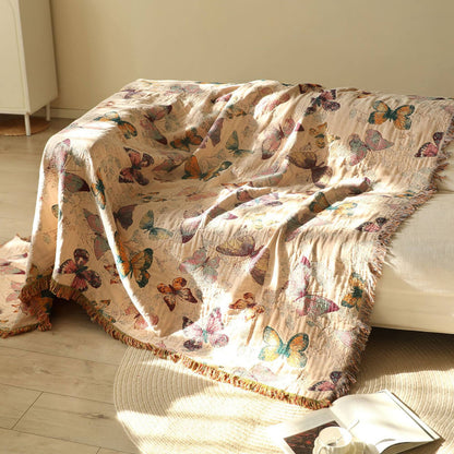 Warm beige butterfly cotton throw blanket draped over a sofa with fringe edges