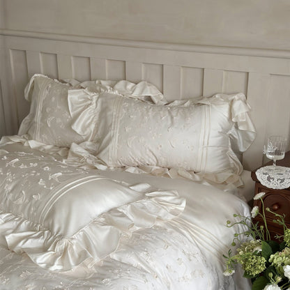 White bedding set with ruffles on a bed in a bedroom setting.