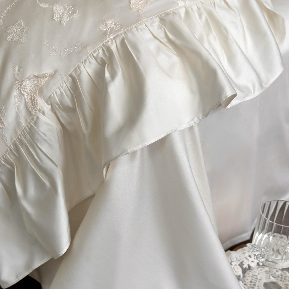 Detail shot of the silky ruffled edge of the Butterfly Embroidered Bedding Set, highlighting the fine stitching.