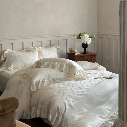 Full view of the cream-colored Butterfly Embroidered Bedding Set with ruffles, styled in a bright bedroom.