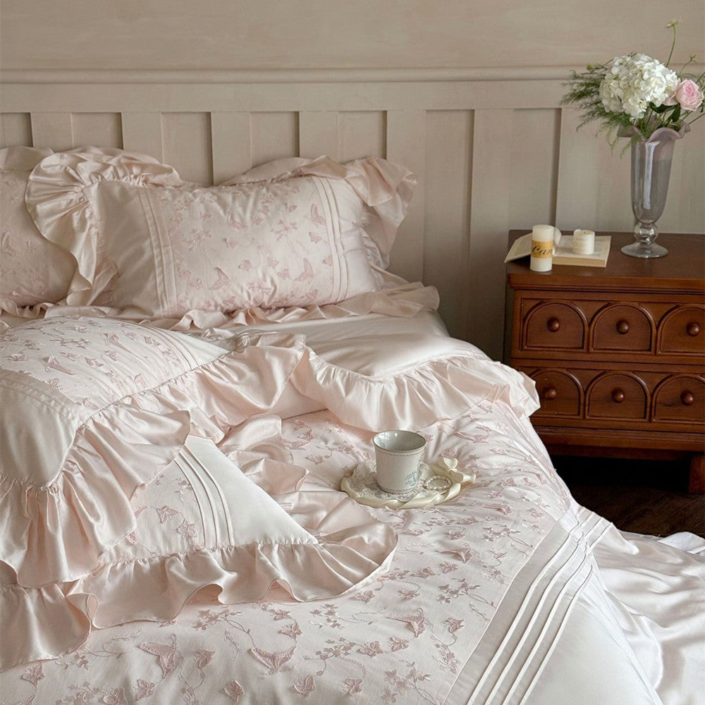 Close-up of the pink Butterfly Embroidered Bedding Set showing a pillow with ruffles and butterfly embroidery.