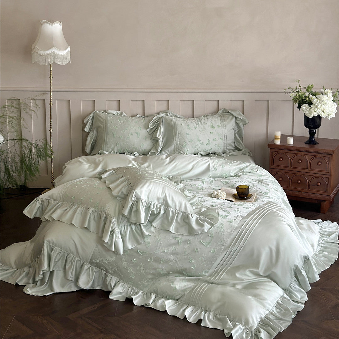 Full view of the light green Butterfly Embroidered Bedding Set with ruffles on a large bed.