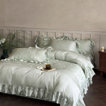 Light green Butterfly Embroidered Bedding Set with ruffles styled on a bed in an elegant room.