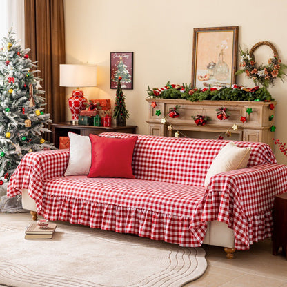 Red buffalo plaid sofa cover with ruffles in a cozy Christmas living room with festive garland and tree