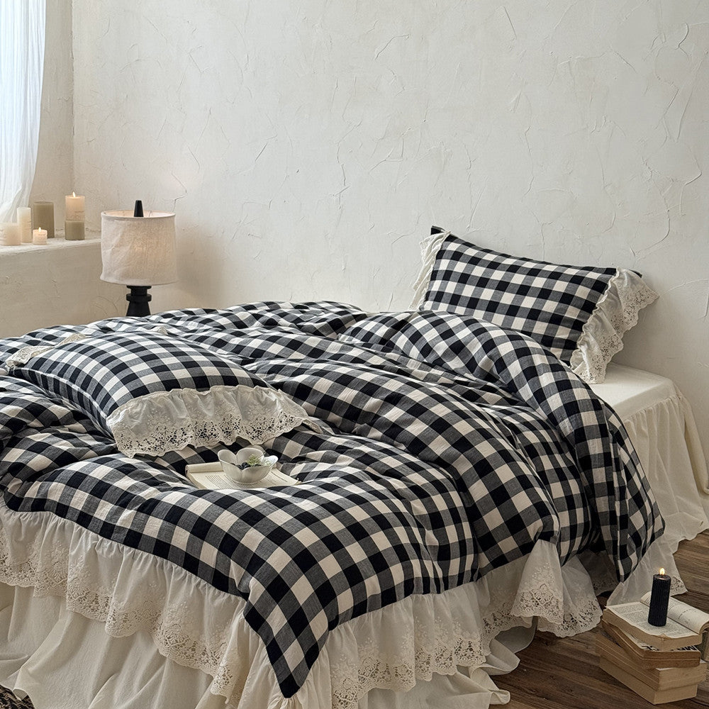 Bed with black and white checkered bedding and lace details in a bedroom setting.