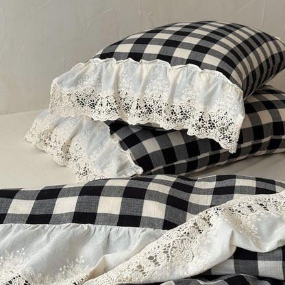 Black and white checkered pillows with lace trim on a neutral background