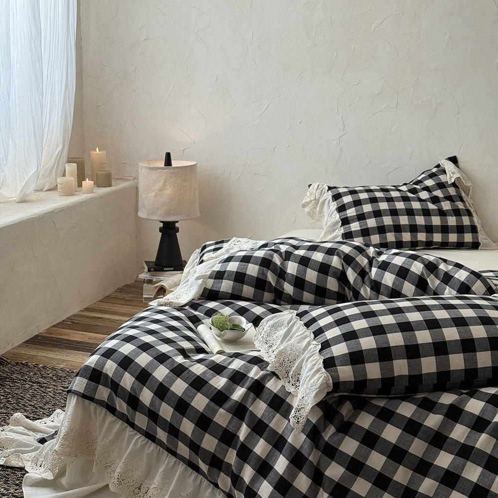 Bed with black and white checkered bedding in a bedroom setting.