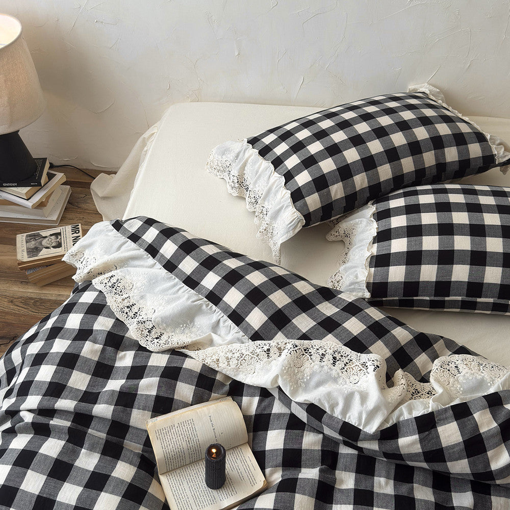 Black and white checkered bedding with lace trim on a bed.