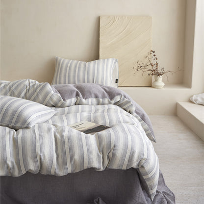Full-bed styled view of the Smoky Gray Striped Bedding Set, emphasizing the clean lines and modern, reversible design.