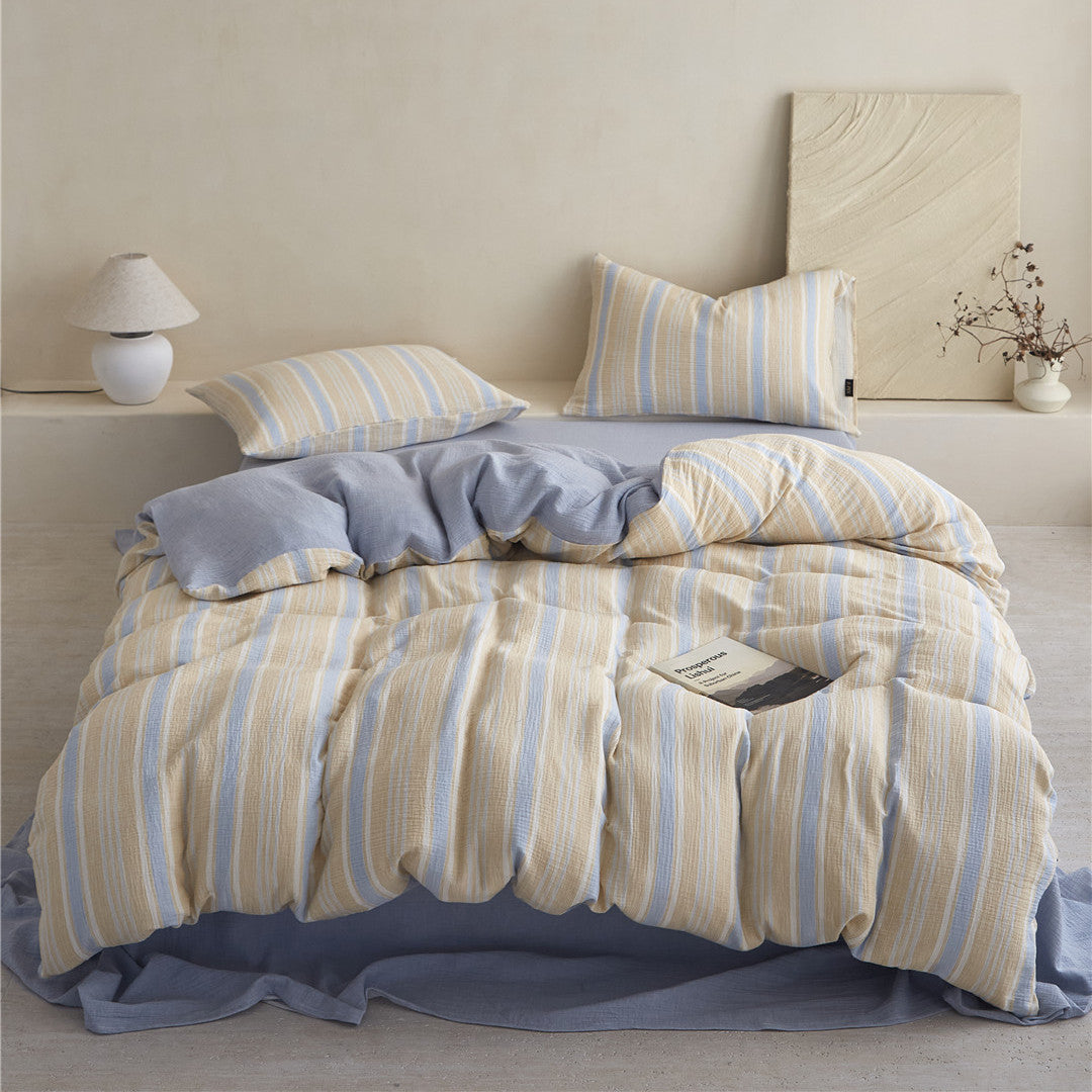 High-quality image of the Yellow & Blue Striped Duvet Cover Set, emphasizing the soft folds and the coordinating solid blue fitted sheet.