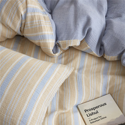 Overhead detail of the Yellow & Blue Stripe pillow and duvet cover fold, focusing on the stripe pattern and the contrasting solid blue reverse side.