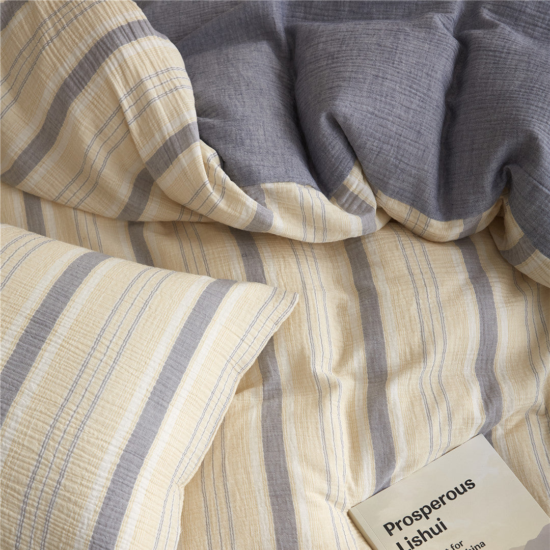 Overhead close-up of the reversible Beige & Grey Duvet Cover, showing the stripe pattern and the solid gray-blue gauze reverse texture.