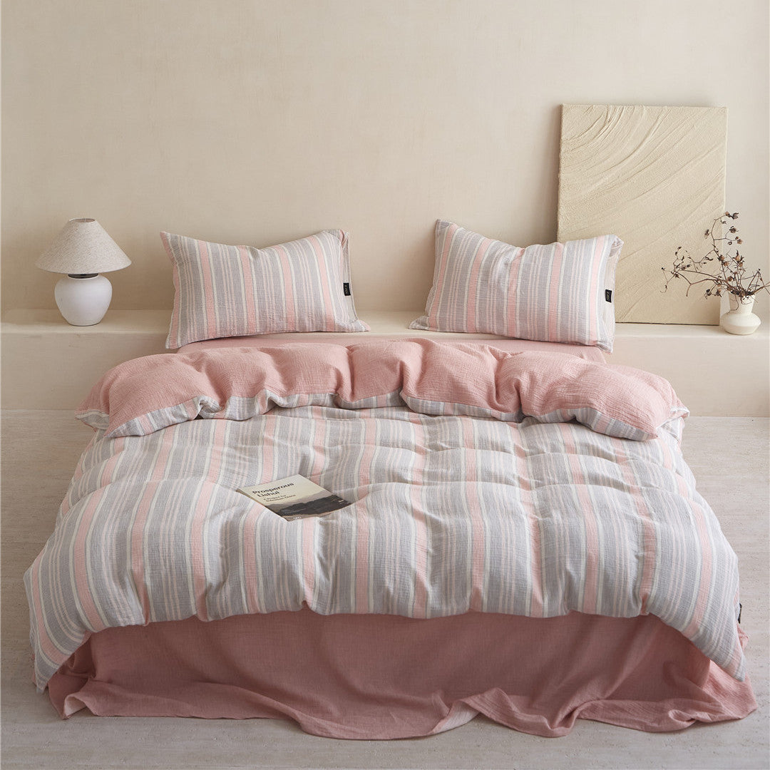 Full view of the Grey & Pale Pink Striped Cotton Gauze Bedding Set, showcasing the reversible pink backing and matching sheet.