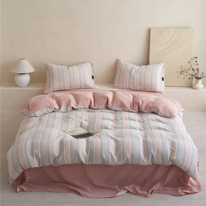 Full view of the Grey & Pale Pink Striped Cotton Gauze Bedding Set, showcasing the reversible pink backing and matching sheet.