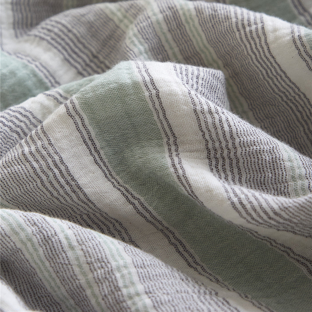 Extreme close-up of the Grey & Pale Green 100% cotton gauze fabric, highlighting the woven texture for the duvet cover.