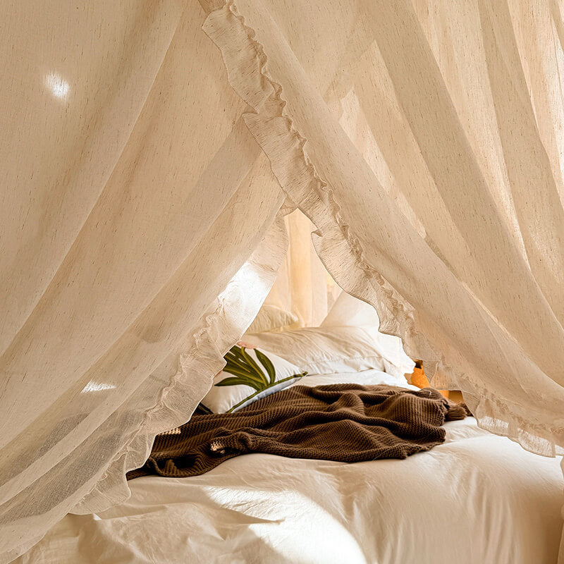 Bed with white canopy and brown blanket, soft lighting