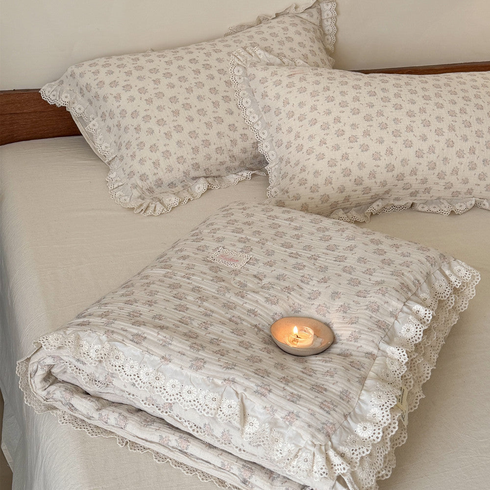 Folded view of a thick and warm country style floral comforter, showing the beautiful contrast between the patterned top and solid neutral reverse.