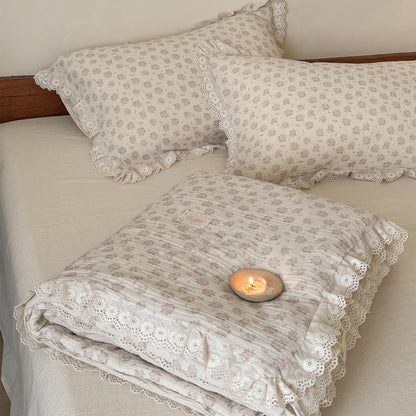 Folded view of a thick and warm country style floral comforter, showing the beautiful contrast between the patterned top and solid neutral reverse.