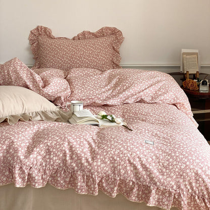 Close-up of the pink ditsy floral bedding set, focusing on the soft texture of the cotton muslin duvet and the scalloped ruffled edges.