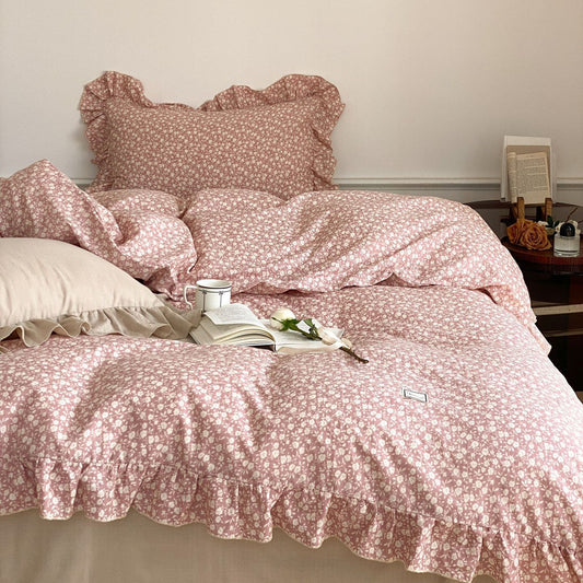 Close-up of the pink ditsy floral bedding set, focusing on the soft texture of the cotton muslin duvet and the scalloped ruffled edges.