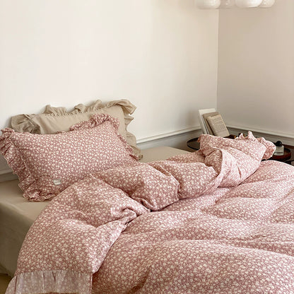 Close-up shot of the pink ditsy floral print duvet and pillow, displaying the cozy drape of the cotton muslin fabric.