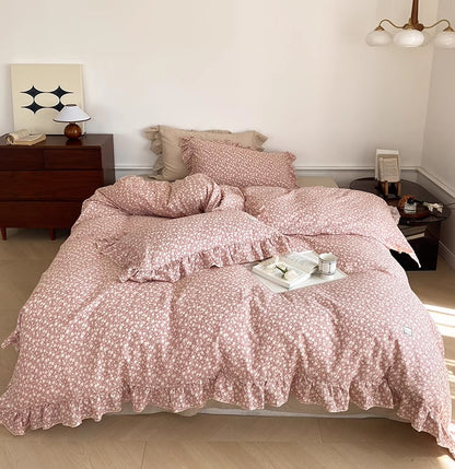 Full shot of the pink Ditsy Floral Bedding Set, showcasing the complete look of the cotton muslin duvet cover and shams with ruffled edges in a bright bedroom.