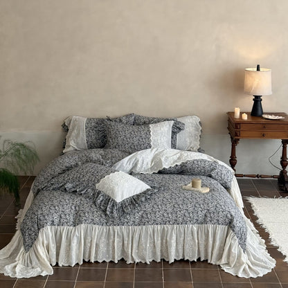 Soft gray botanical bedding styled with ivory embroidery and vintage bedroom decor