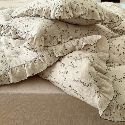 Detail of the Cotton Muslin Twin Size Bedding showing soft ruffle edges and a subtle leaf print.