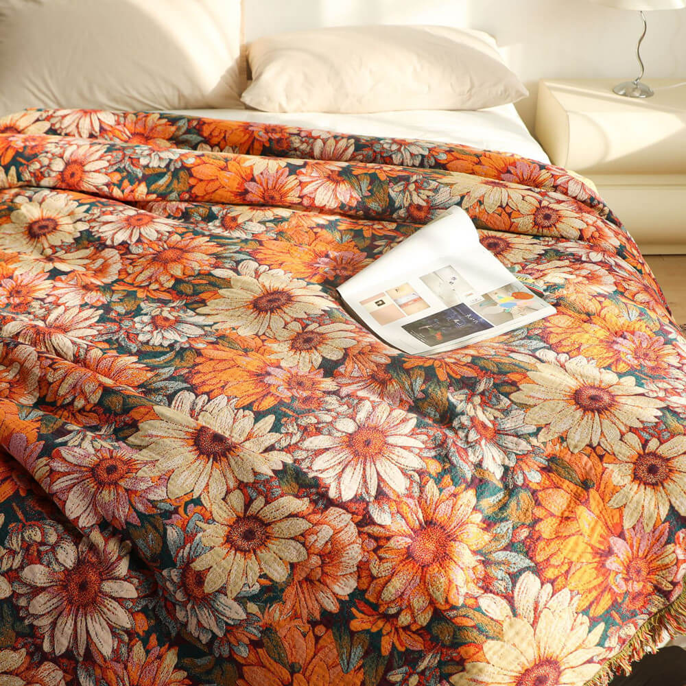 Close-up of daisy floral cotton throw blanket with cream and orange flowers