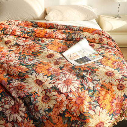 Close-up of daisy floral cotton throw blanket with cream and orange flowers