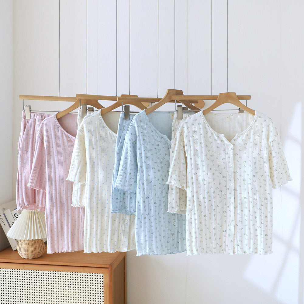 Women’s ditsy floral cotton short sleeve pajama sets in pastel colors hanging on wooden hangers