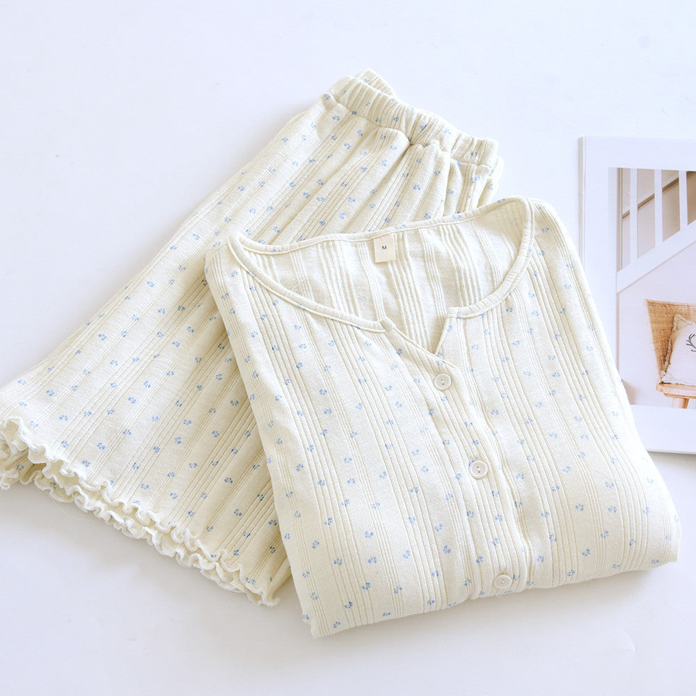 Cream cotton short sleeve pajama set with ditsy blue floral print, folded on white surface