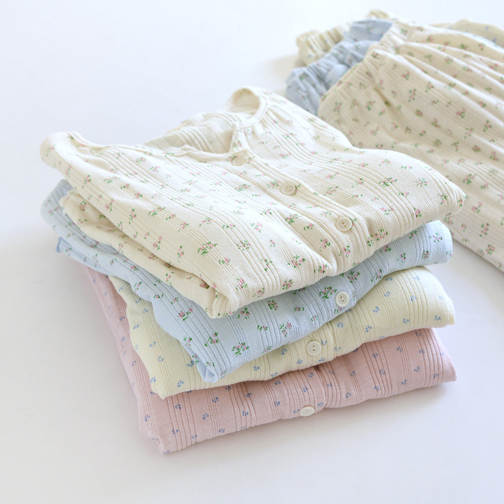 Stack of soft cotton pajama sets with ditsy floral print and short sleeves on white background