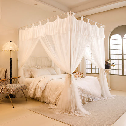Elegant canopy bed with white cotton curtains and bedding in a cozy, sunlit bedroom.