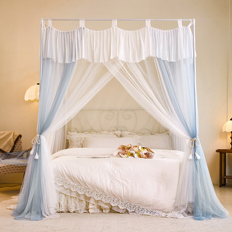 Elegant canopy bed with sheer blue and white curtains, lace bedding, cozy bedroom decor