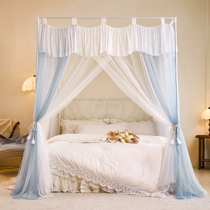 Elegant canopy bed with sheer blue and white curtains, lace bedding, cozy bedroom decor