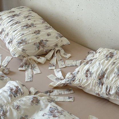 Vintage rose floral cotton muslin bedding set with soft gathered ruching, ribbon-tie edges, and cozy neutral bedroom decor.