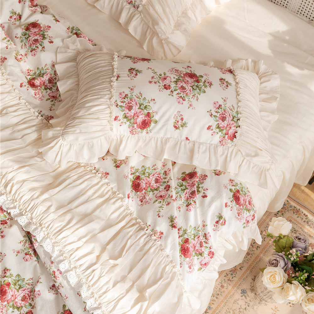 Floral cotton bedding set with ruffles and rose print, featuring matching pillow shams.
