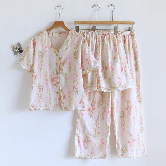 Light pink floral cotton pajama set with short sleeve button-up top and long pants hanging on hangers
