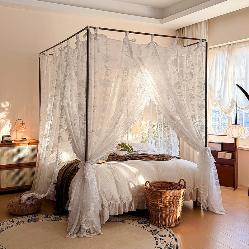 Floral lace canopy curtains on a four-poster bed in a cozy, sunlit bedroom