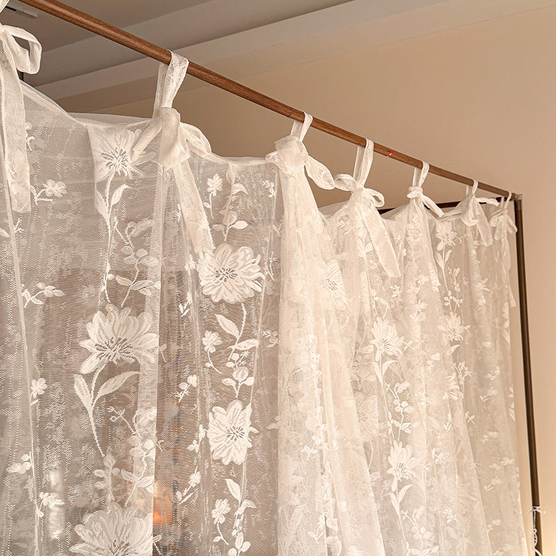 Sheer floral lace canopy curtains on a four-poster bed, elegant and romantic bedroom decor