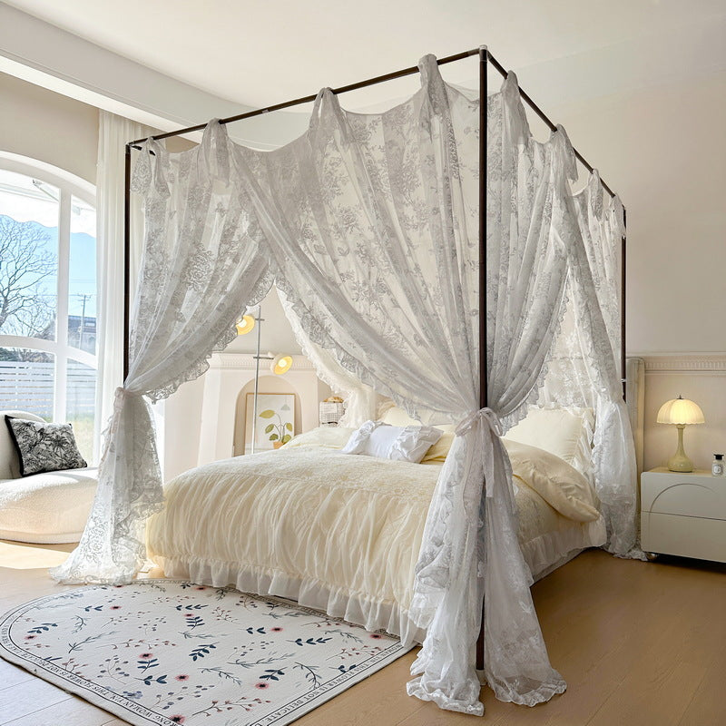 Floral lace canopy curtains on a four-poster bed in a bright, elegant bedroom